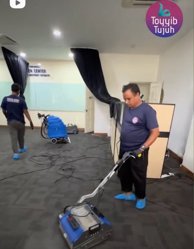 Pasukan Toyyib Klean mencuci karpet pejabat dengan mesin.