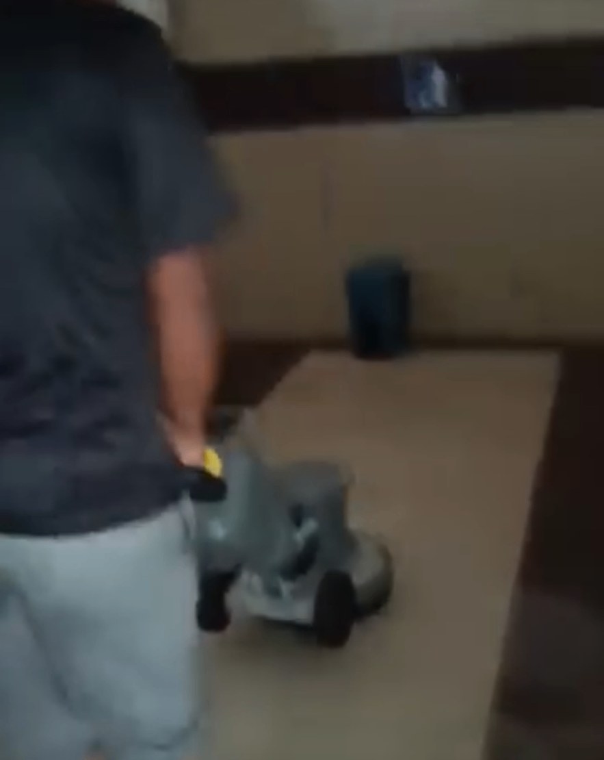 Kerja scrubbing lantai menggunakan mesin di ruang pejabat.